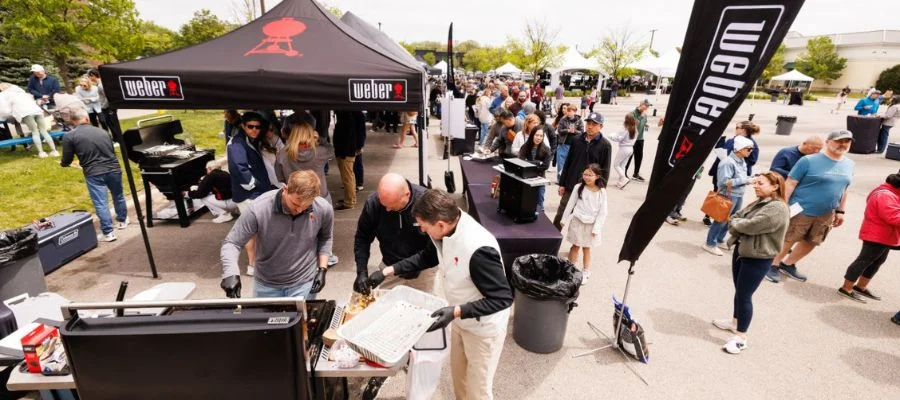 The weber booth at a past Abt grill fest. People are lining up to try different foods.
