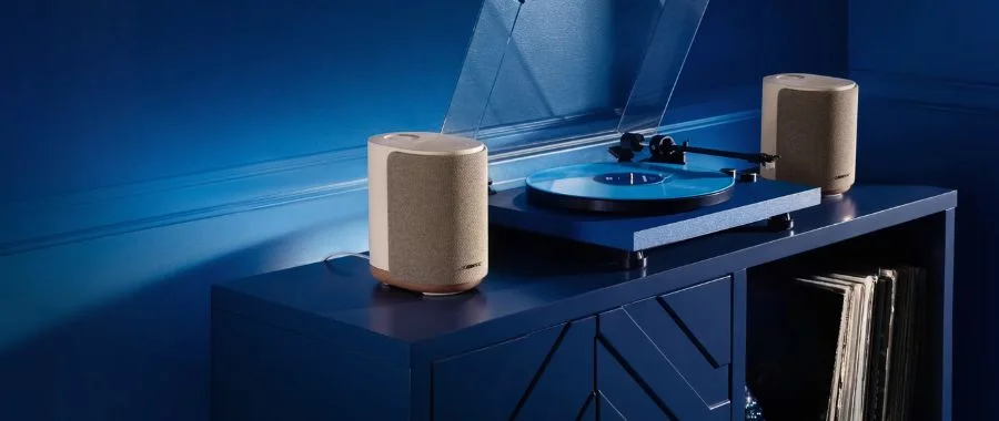 Two stereo paired Bose Lifestyle Ultra speakers on either side of a blue turntable.
