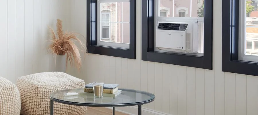 A window air conditioner cooling a modern, minimalist apartment room,