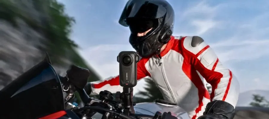 Person wearing a helmet riding a motorcycle with an Insta360 X6 camera mounted on the handlebar.