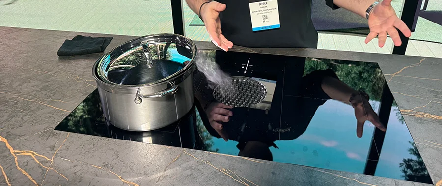 stainless steel pot sitting on black induction cooktop with downdraft
