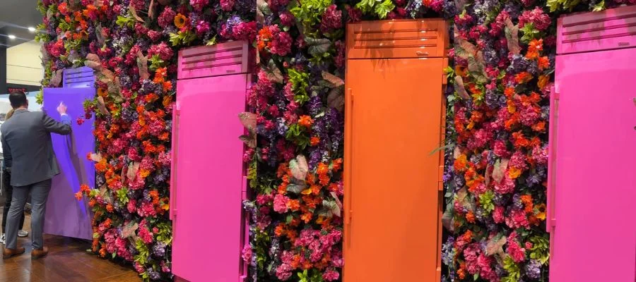 Bright-hued true refrigerator columns in orange, pink and purple. They're set into a wall of florals