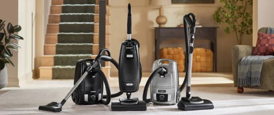 The Kirby Signature Series of vacuums beside each other in a living room.