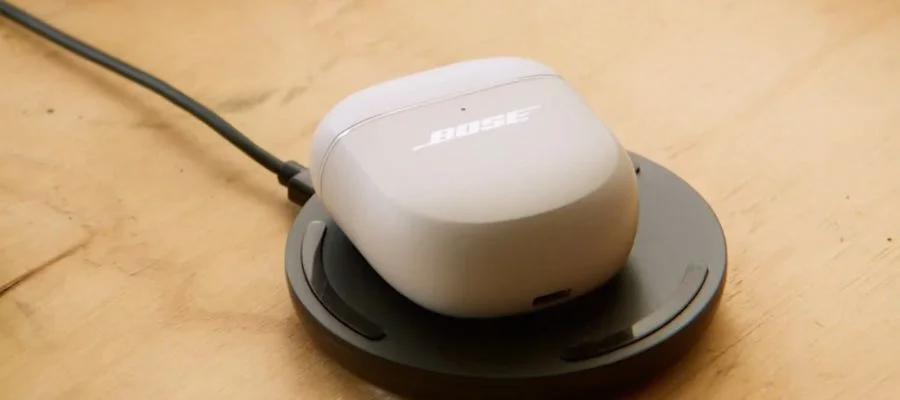The Bose QuietComfort Ultra Earbuds 2 in white wirelessly charging.