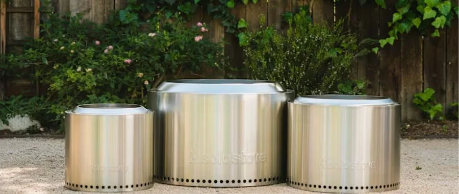 Three stainless steel Solo Stove fire pits in different sizes next to each other.