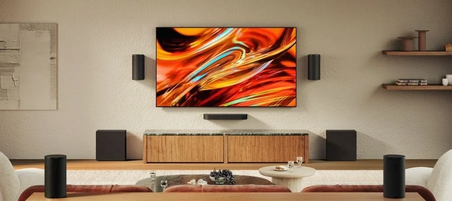 Sony Bravia Theater Trio speakers wall mounted with Sub 9 subwoofers on both sides of the TV stand and Rear 9 speakers behind the sofa.