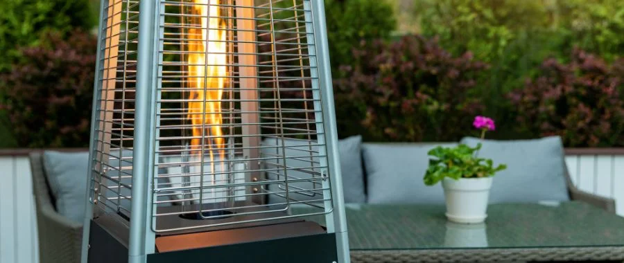 A sleek, pyramid outdoor heater on a simple, modern patio.