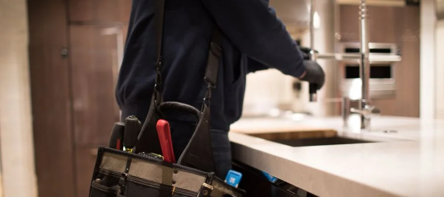 Abt plumber repairing kitchen sink.