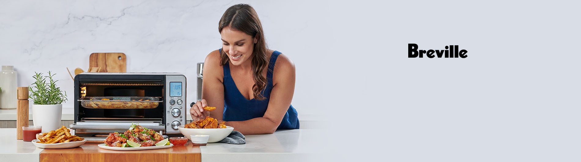 Woman enjoying snacks next to countertop oven