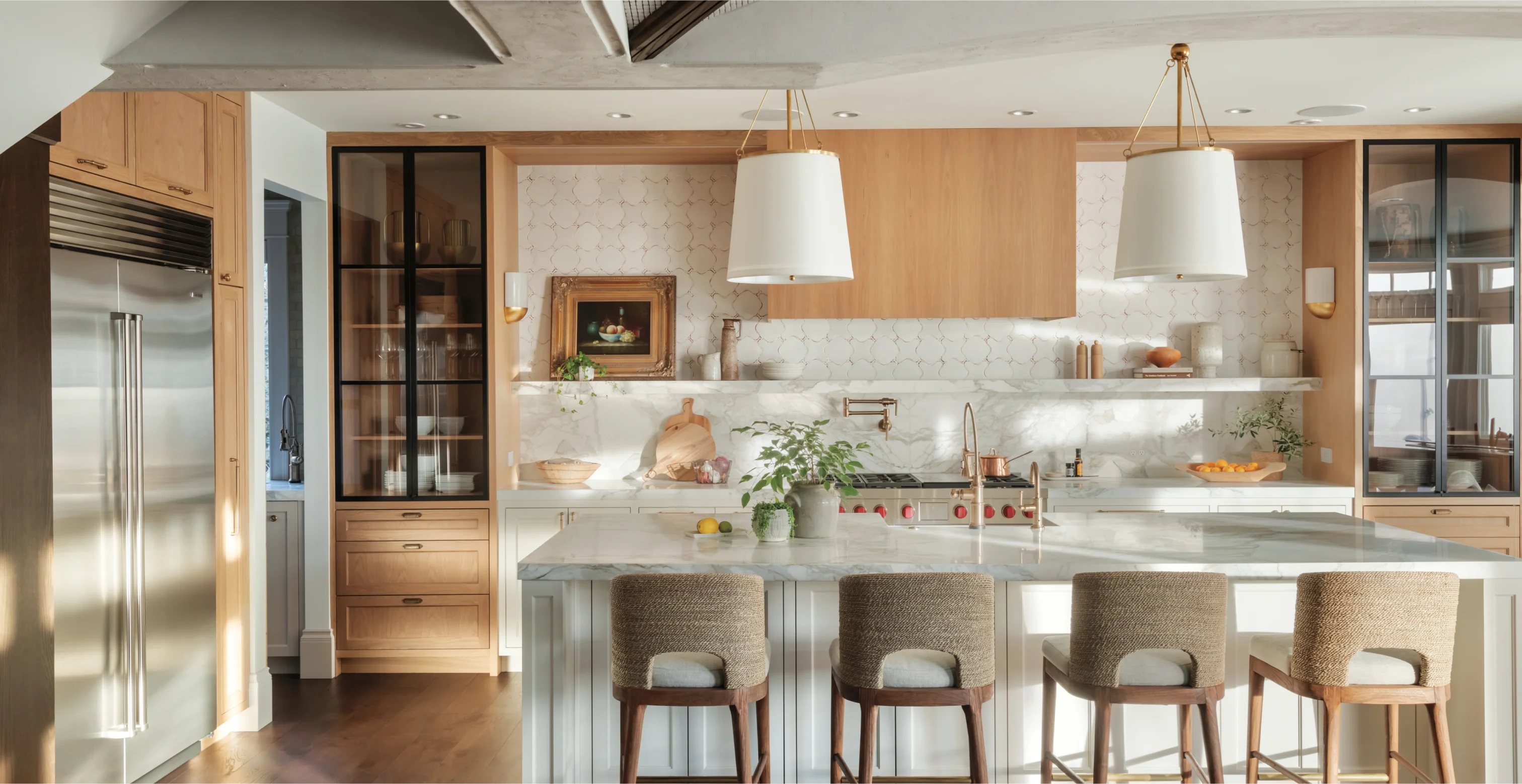 widescreen view of luxury kitchen with Wolf and Sub Zero stainless steel appliances and white marble counters