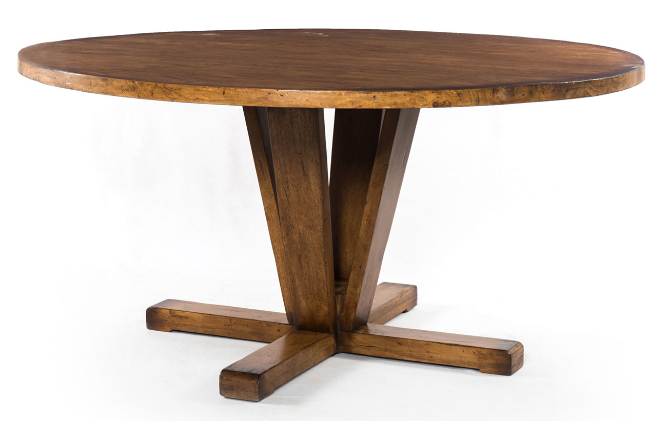 Round wooden dining table with a thick top and sculpted angled pedestal legs forming a cross base.