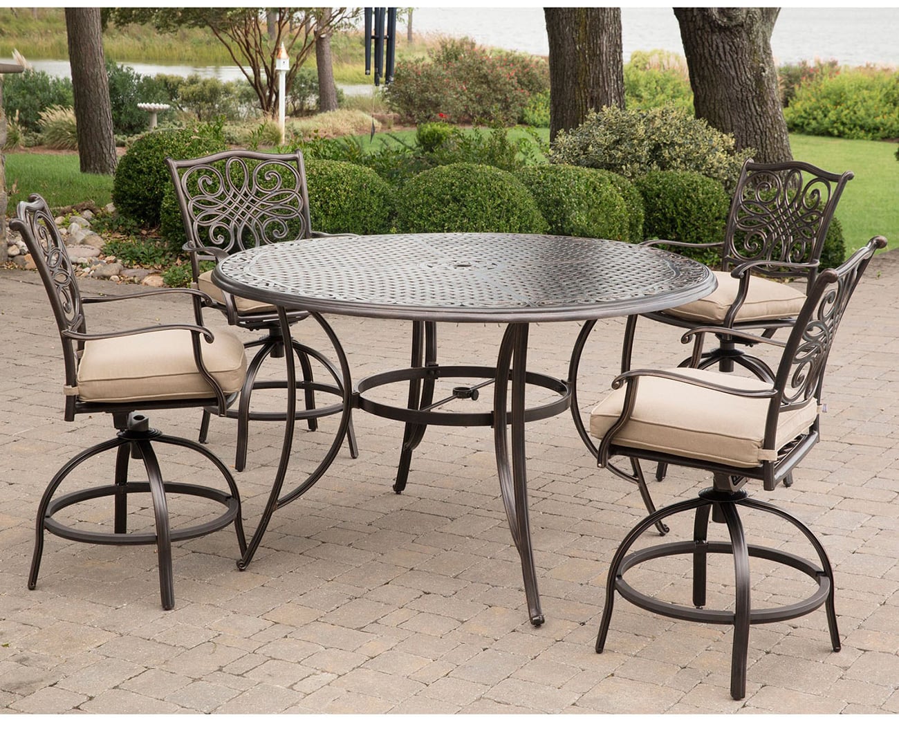 Round metal dining table with intricate lattice top and curved legs, matching outdoor chairs