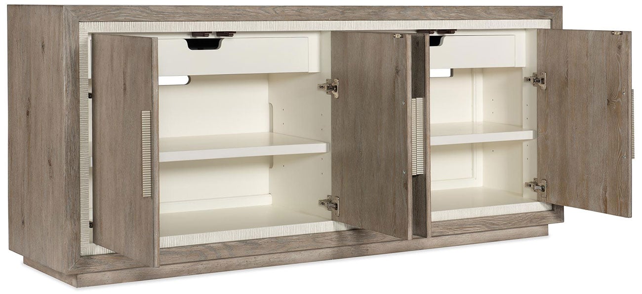 A wooden cabinet with four doors open, revealing white shelves inside.