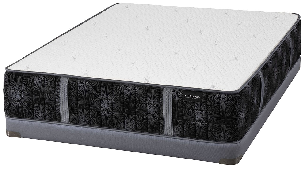 Floor-level perspective of mattress with metal bed rail support on the front edge.