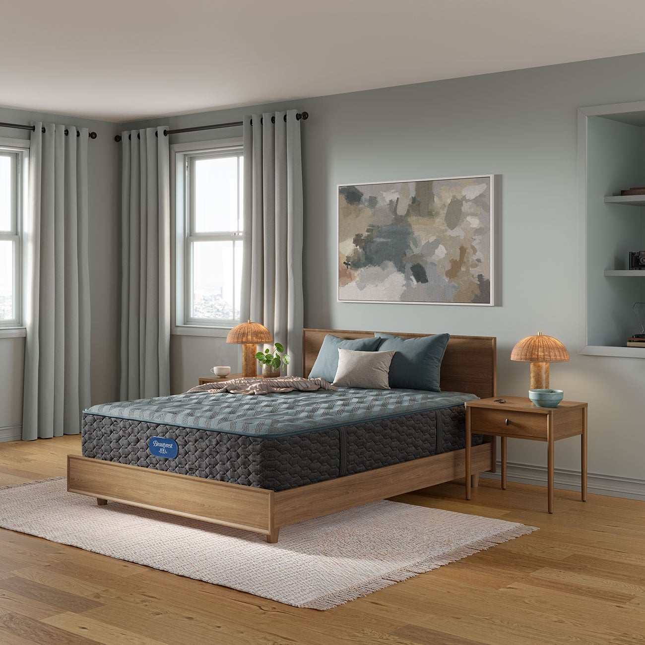 Side view of a gray quilted medium profile mattress with teal piping and a Beautyrest 100 badge, shown on a platform bed frame.