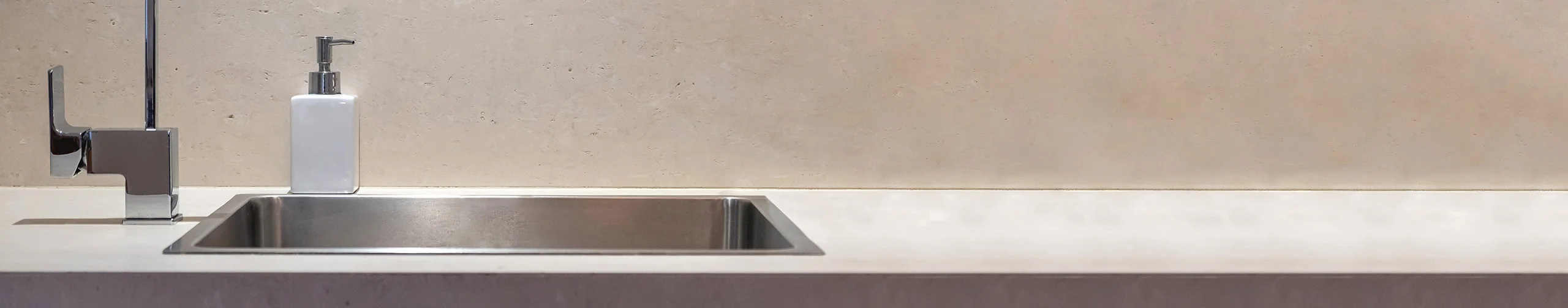 Minimalist kitchen sink, ready to be cleaned with soap nearby