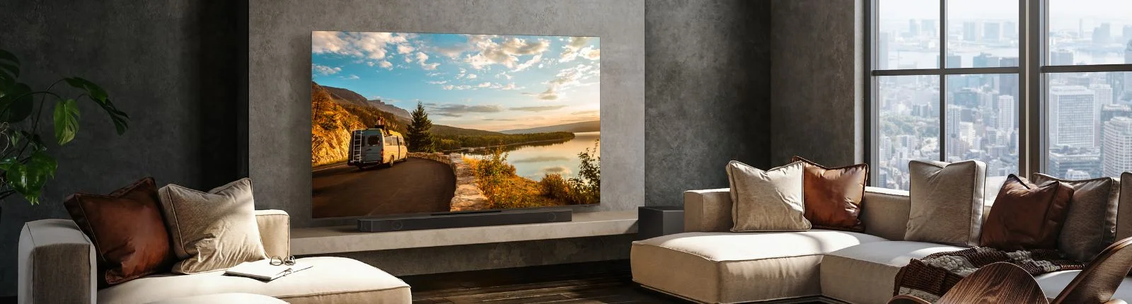 Large QLED TV mounted on a wall with a soundbar underneath in front of a large tan sectional.