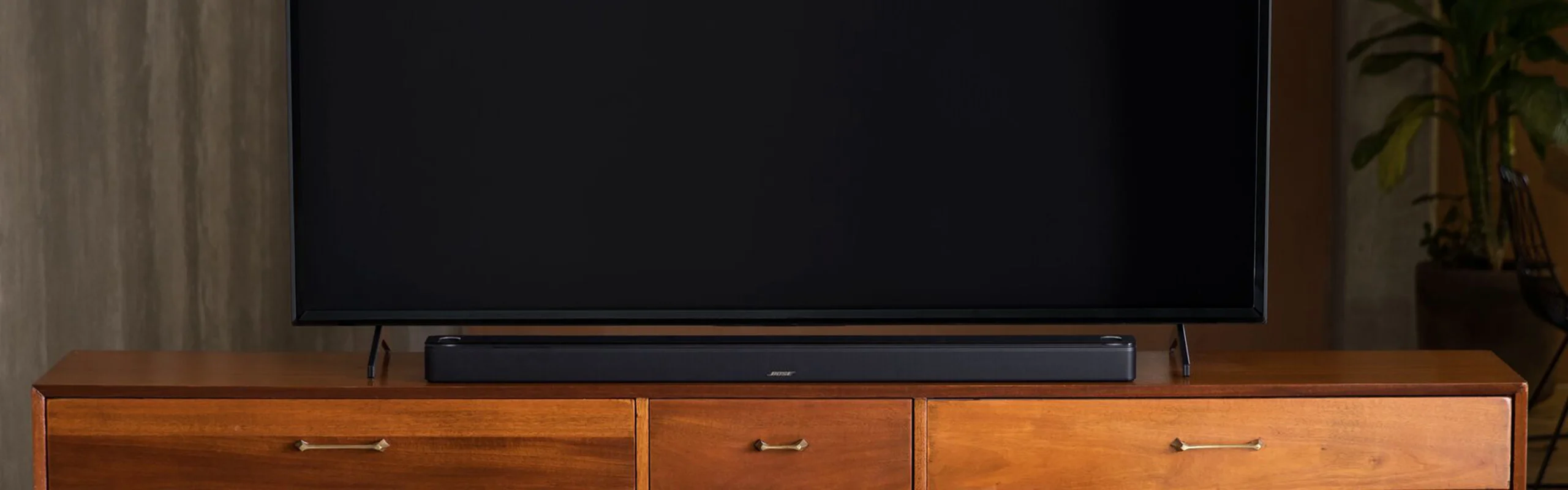 A black soundbar in front of a television