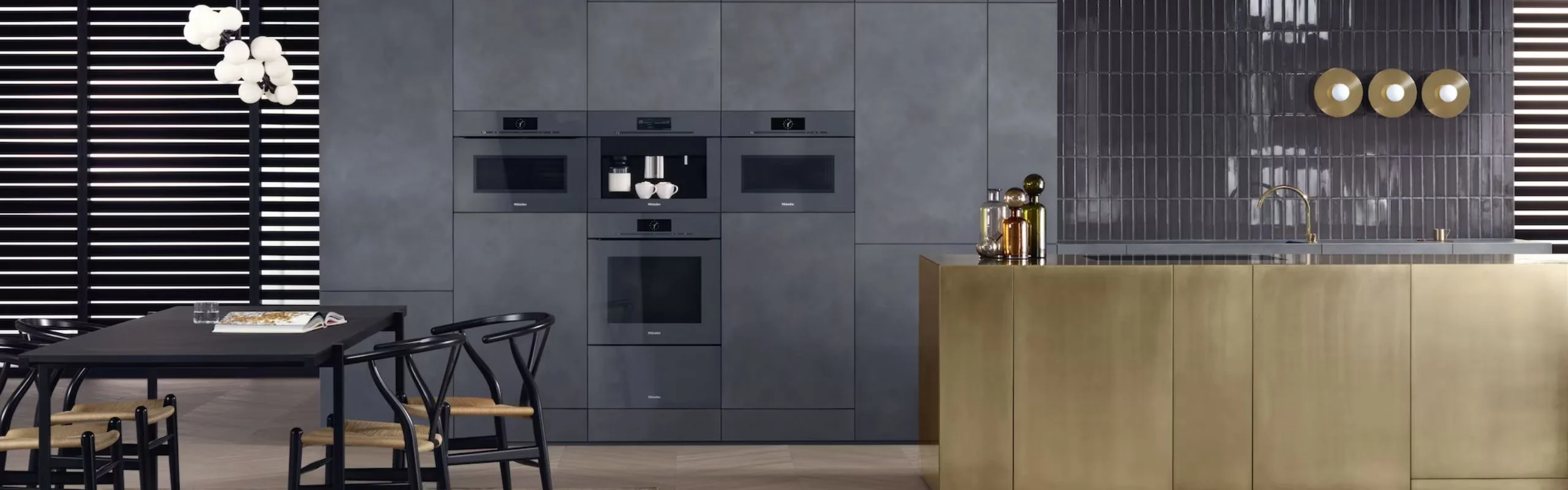 A black and gray kitchen complete with built-in Miele appliances, including a built-in coffee machine.