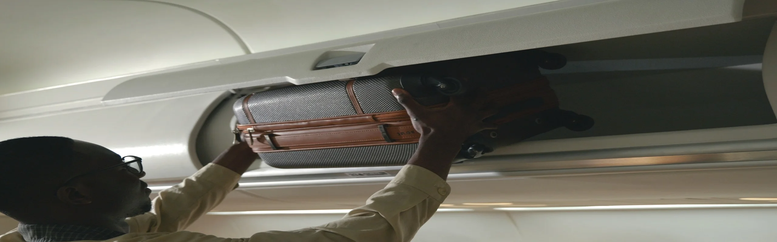 Man putting luggage in overhead bin