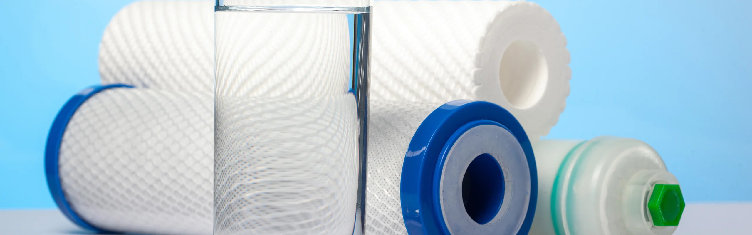 Glass of water in front of stack of water filters