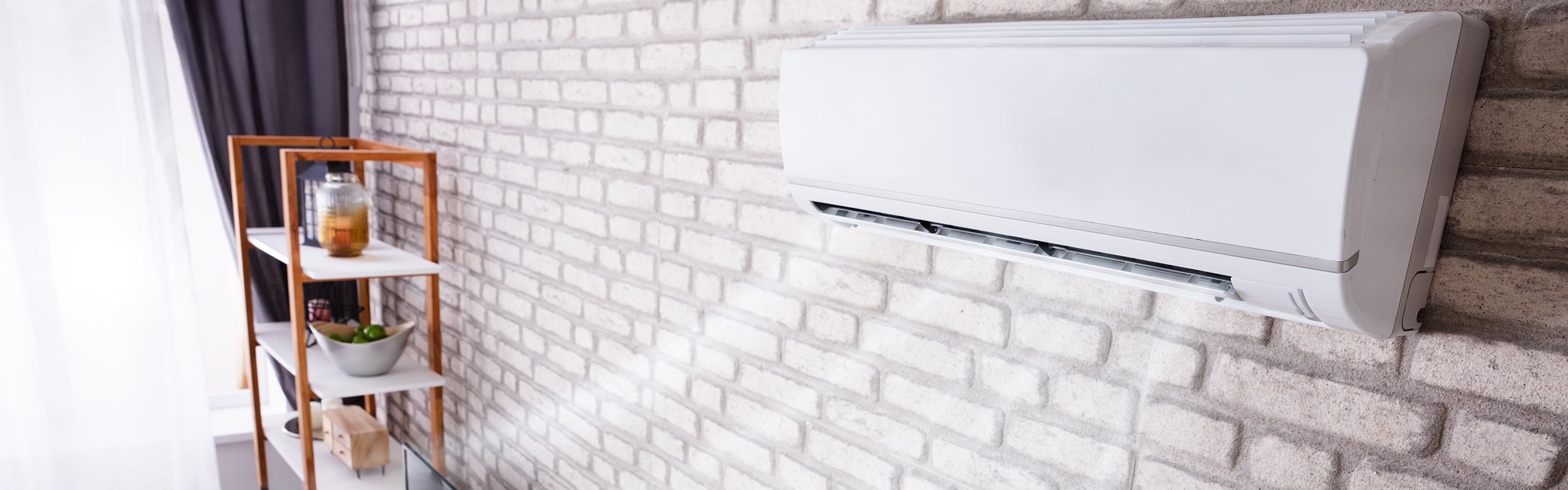 White wall air conditioner blowing cold air into a living room