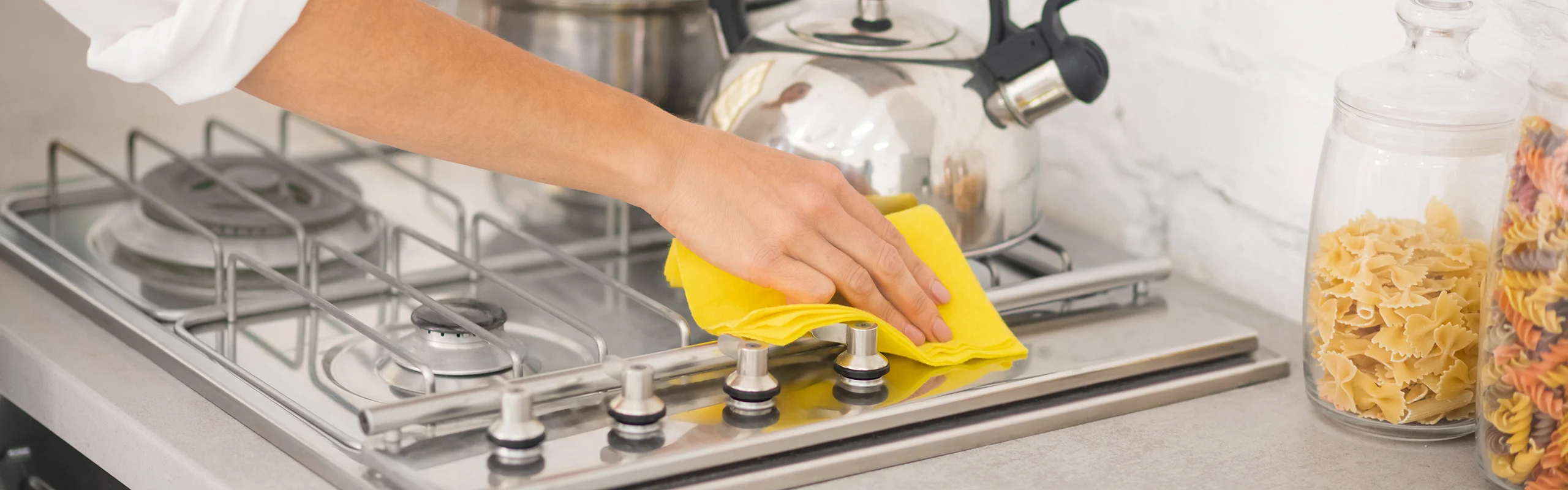 Gloved hand cleaning cooktop