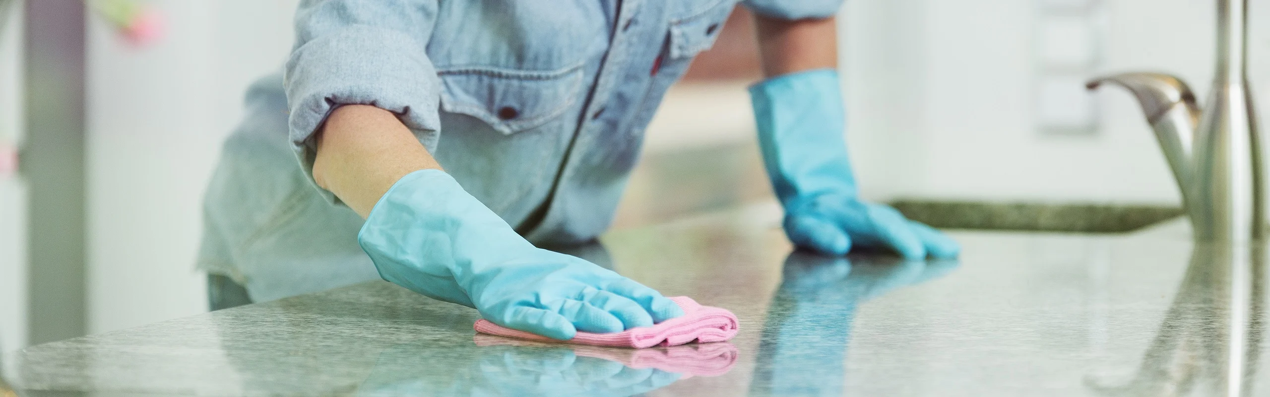 Woman with gloves cleaning tabletop
