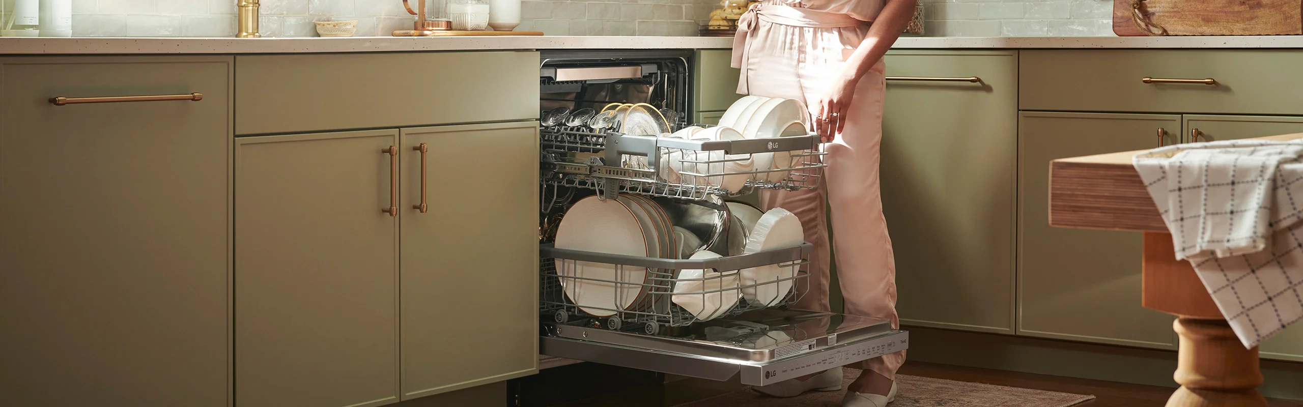 woman in pink clothing loading a dishwasher