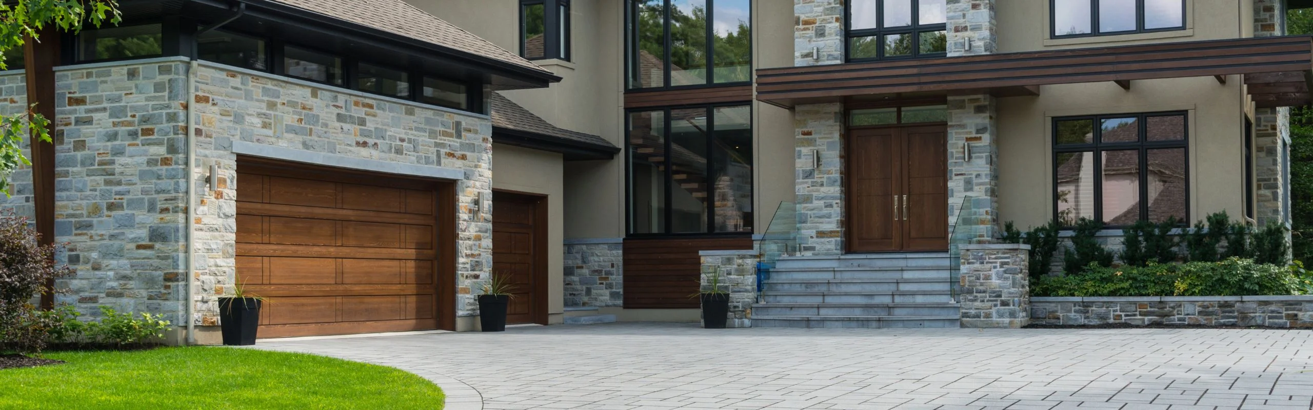 A traditional, rich brown garage door attached to a modern stone garage.