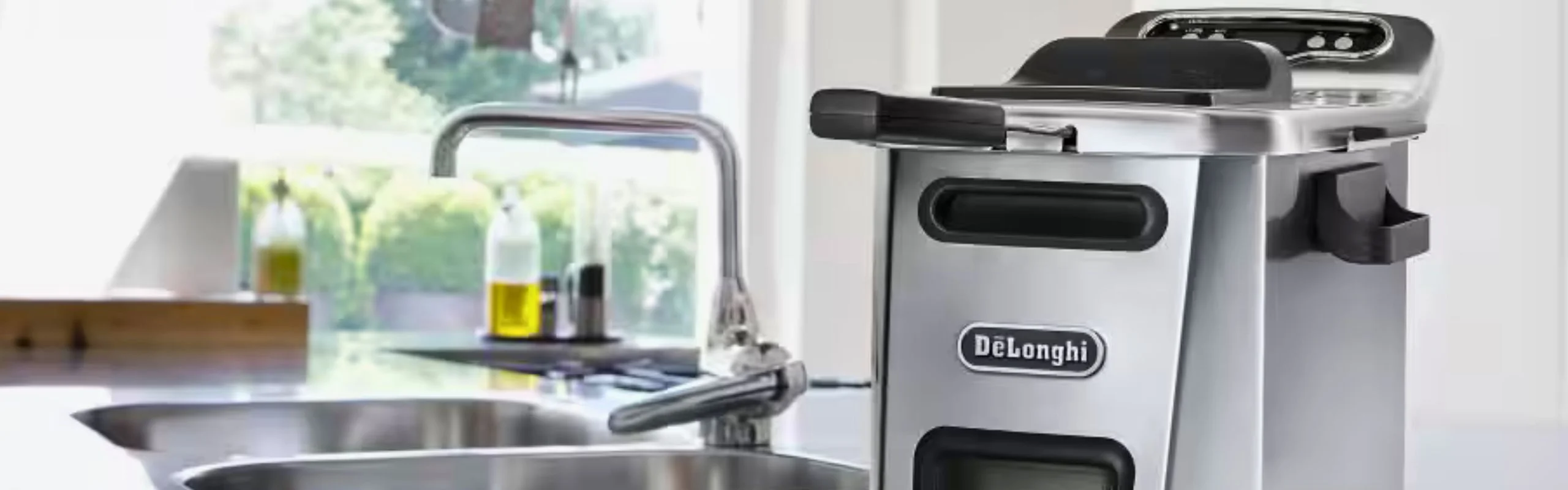 A countertop DeLonghi deep fryer sitting near a sink in a modern kitchen.