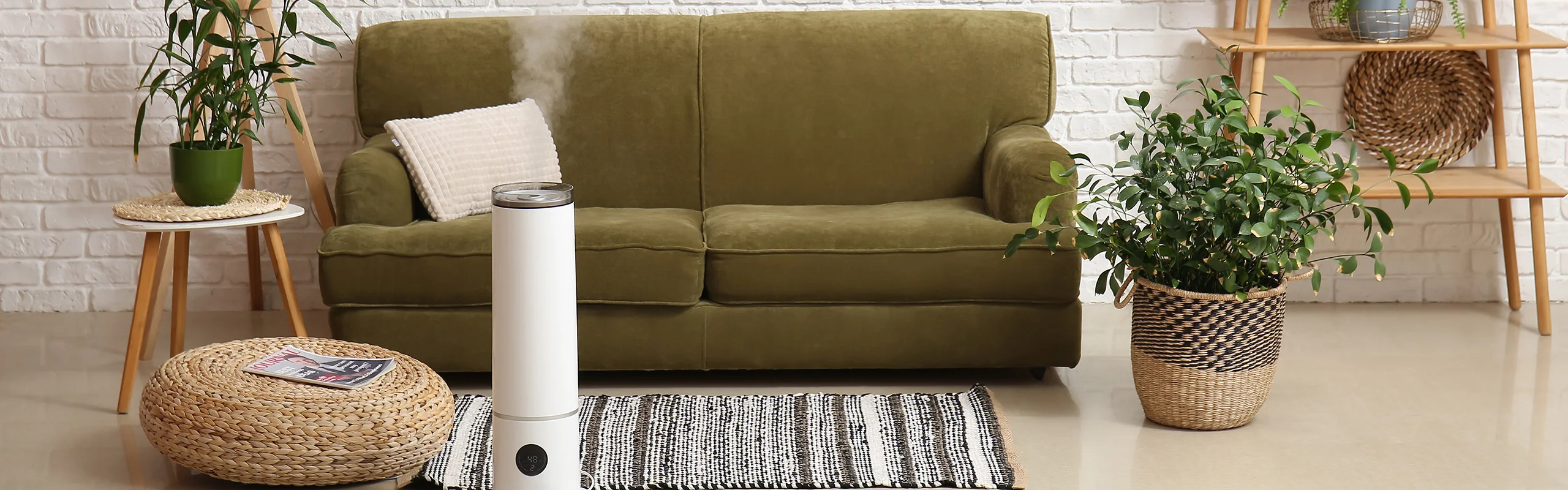 A white humidifier sitting on the floor and releasing mist into a green accented living room