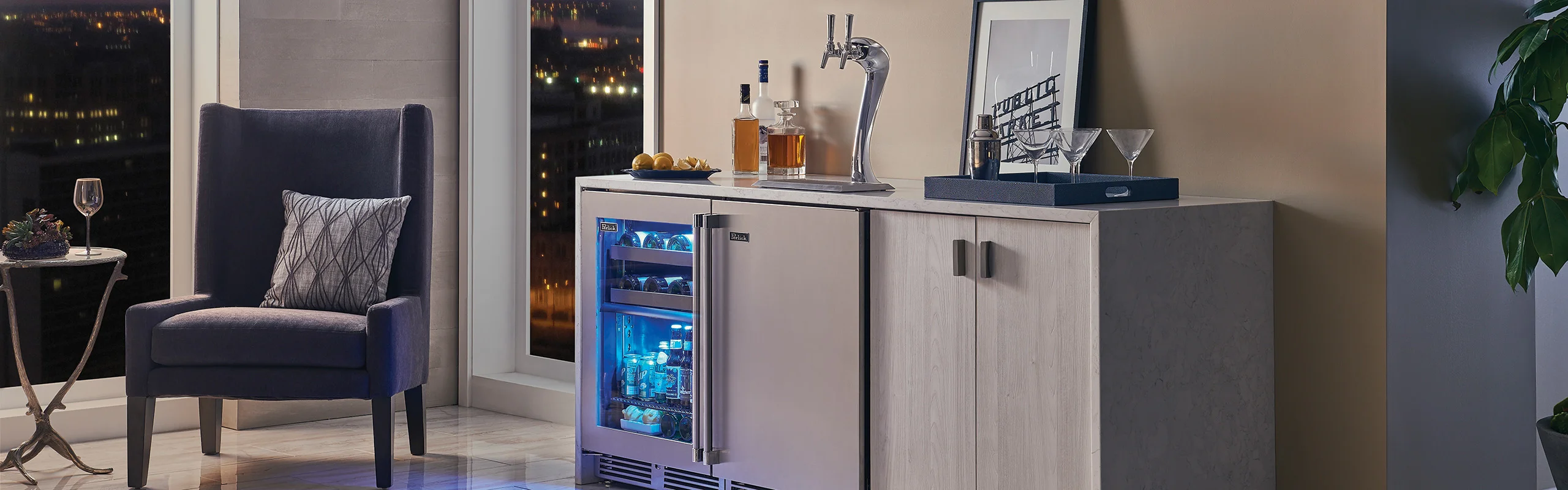 A stainless steel kegerator installed in a cabinet next to a beverage center
