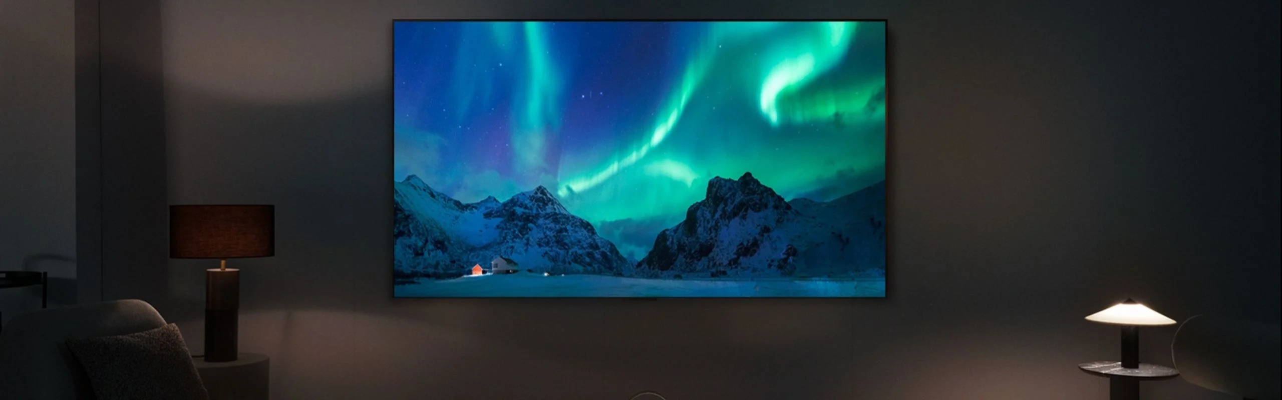 A TV showcasing the bright colors of the Aurora Borealis against a dark wall in a dark room