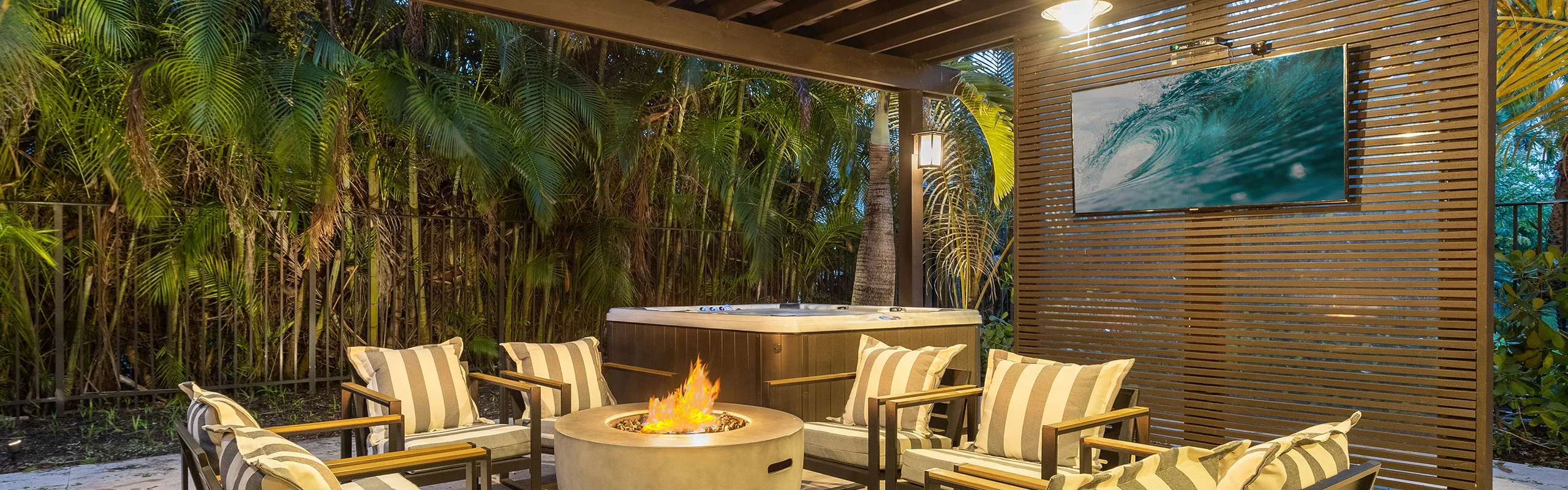 A modern outdoor TV mounted on a wall, displaying vibrant content in a picturesque outdoor setting.