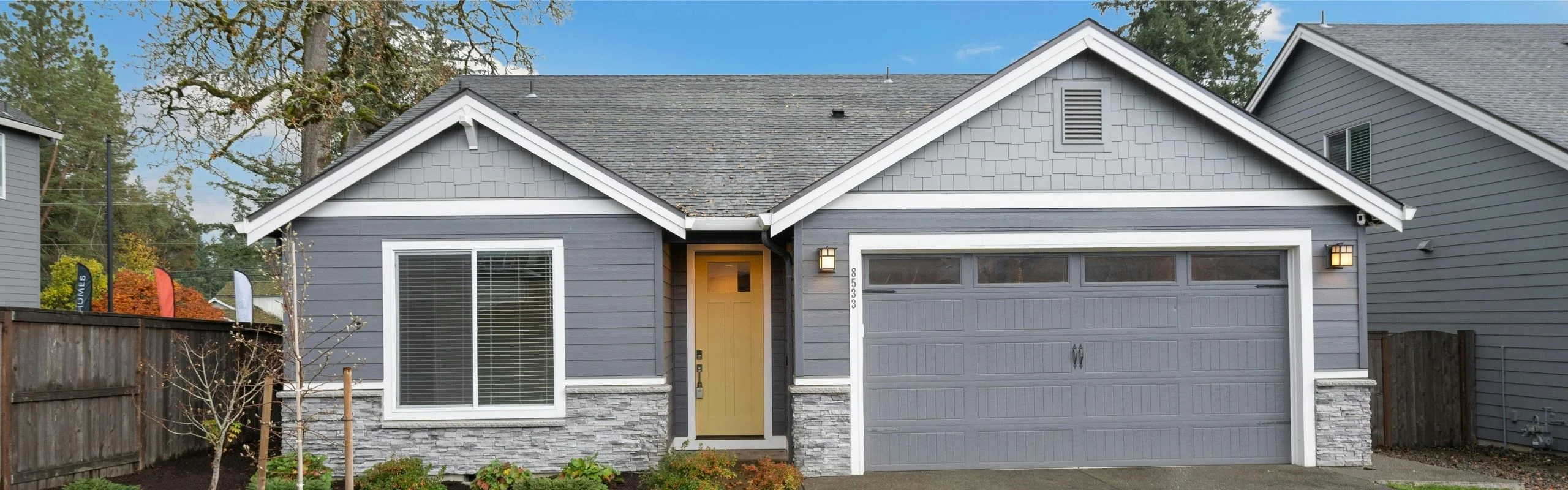 An image of a gray single-story house with a gray garage door