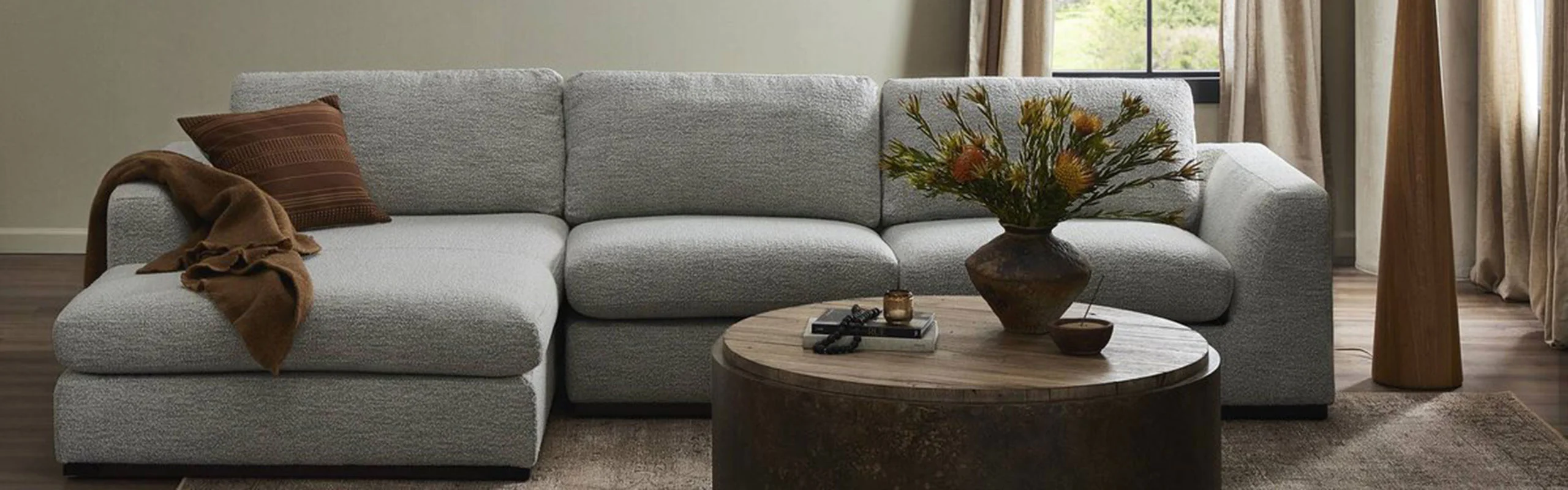 grey sectional with round coffee table in front of it