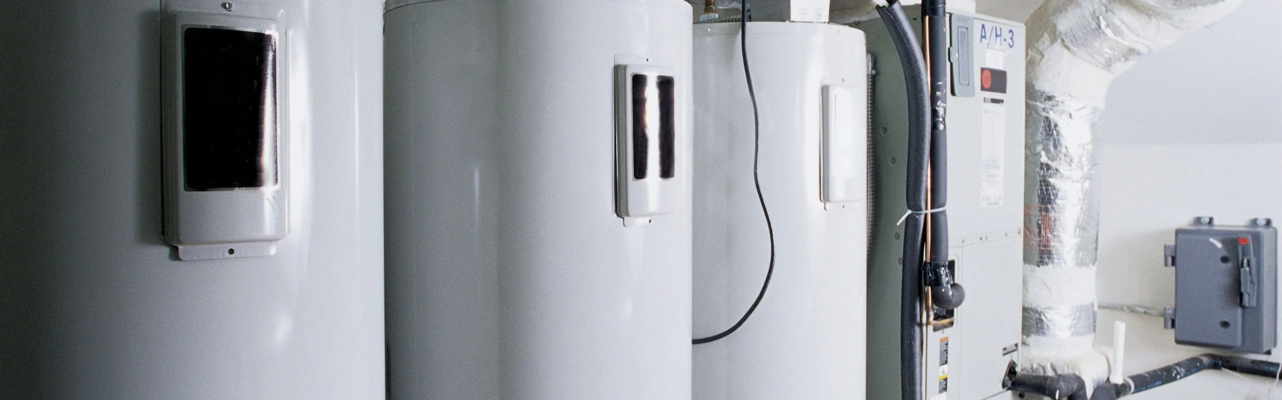 A zoomed in view of tank water heaters lined up in a row