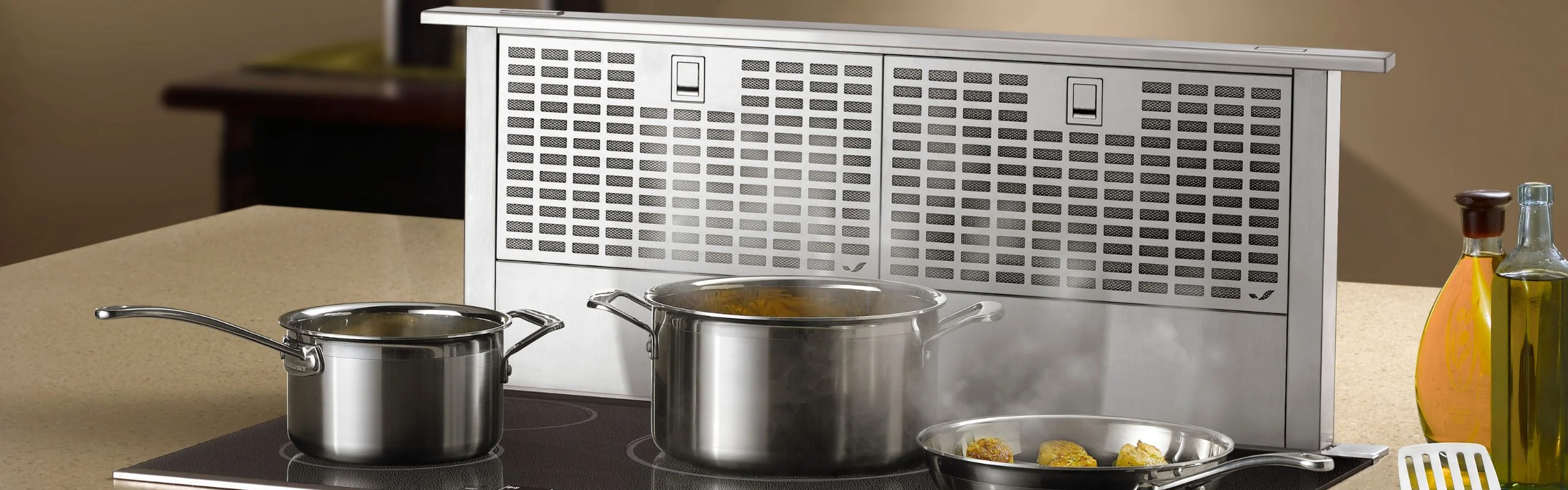 A downdraft ventilating a cooktop from the side in a modern kitchen.