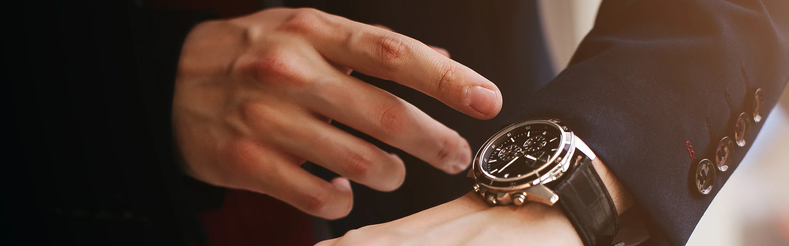 person in a dark suit wearing a wristwatch